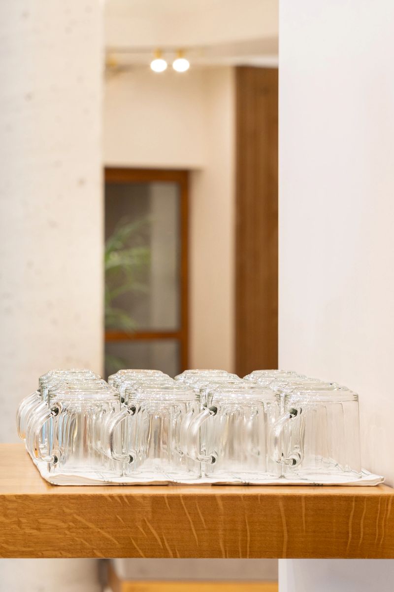 Rows of clean glass cups on table, tea mug service board