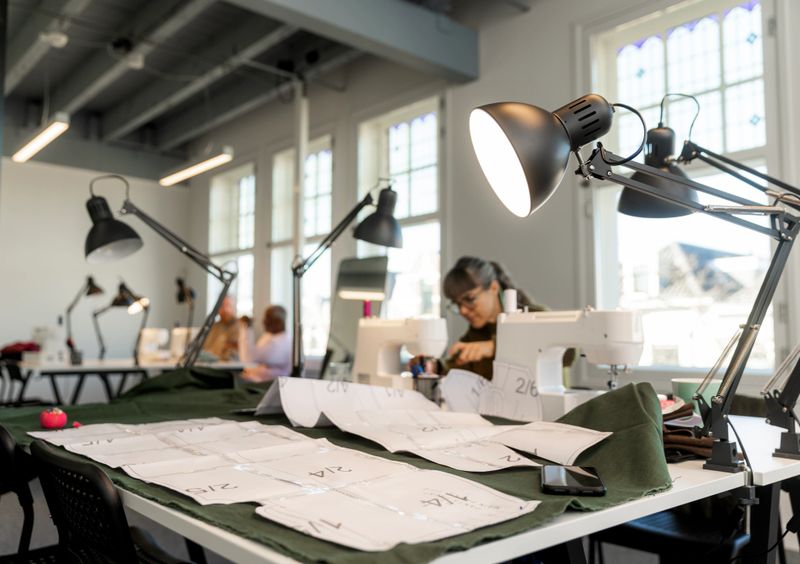Diverse adult student men and woman learning a new skill at a sewing School