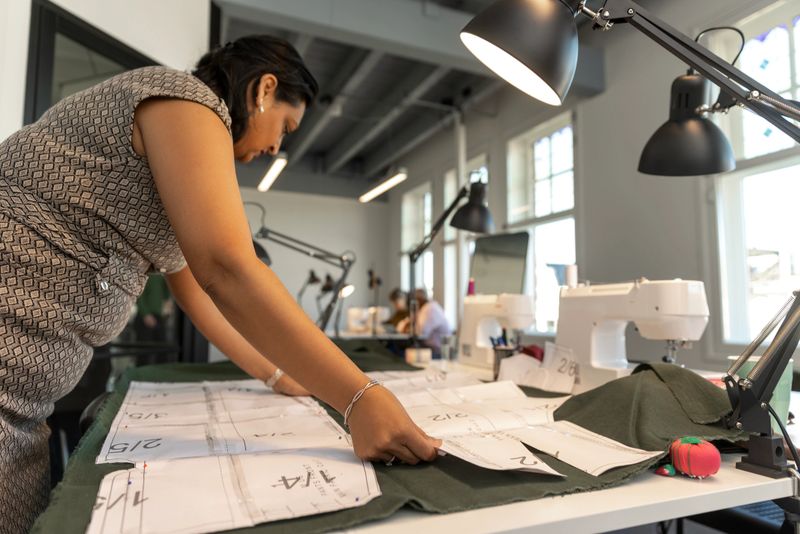 Diverse adult student men and woman learning a new skill at a sewing School