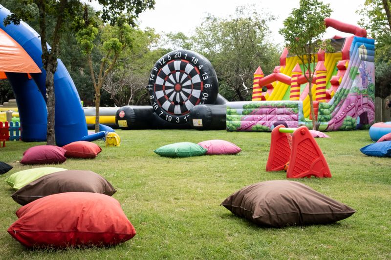 A relaxing space playground with large pillows and inflatables over grassy area. A fun playground for kids and their parents.
