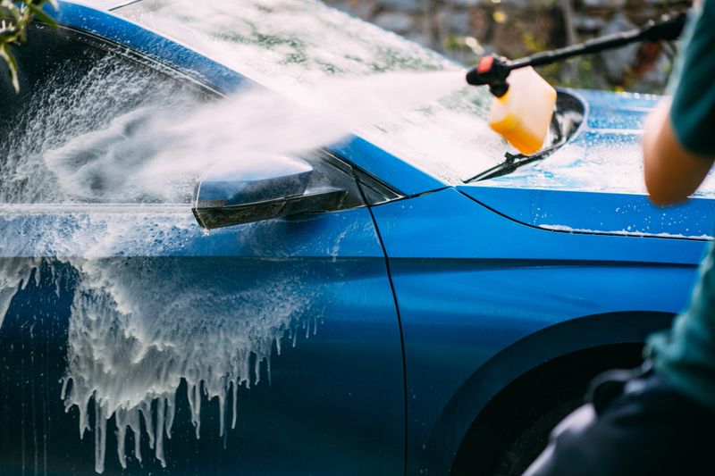 Man Washing Car in His Garden With Pressure Washer
