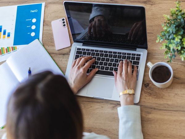Woman typing on laptop.