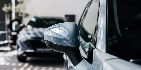 Close-up of a car's side mirror with another car in the background.
