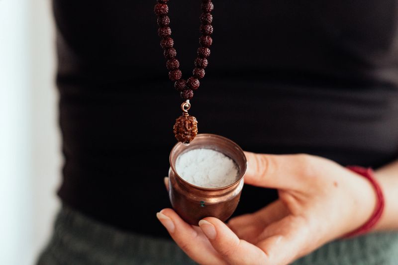 Vibhuti sacred ash in a copper container with Rudraksha mala. Spiritual Hindu ritual.