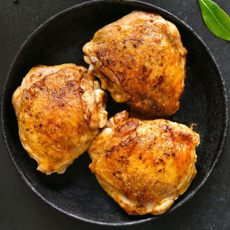 Roasted chicken thighs on plate. Top view, flat lay