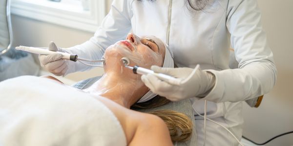 Woman receiving a facial treatment with electric devices.