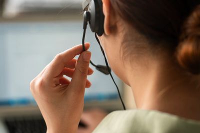 Person wearing a headset, working on a laptop.