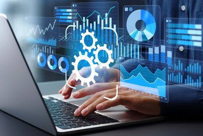 Person typing on a laptop with digital data analytics overlays.