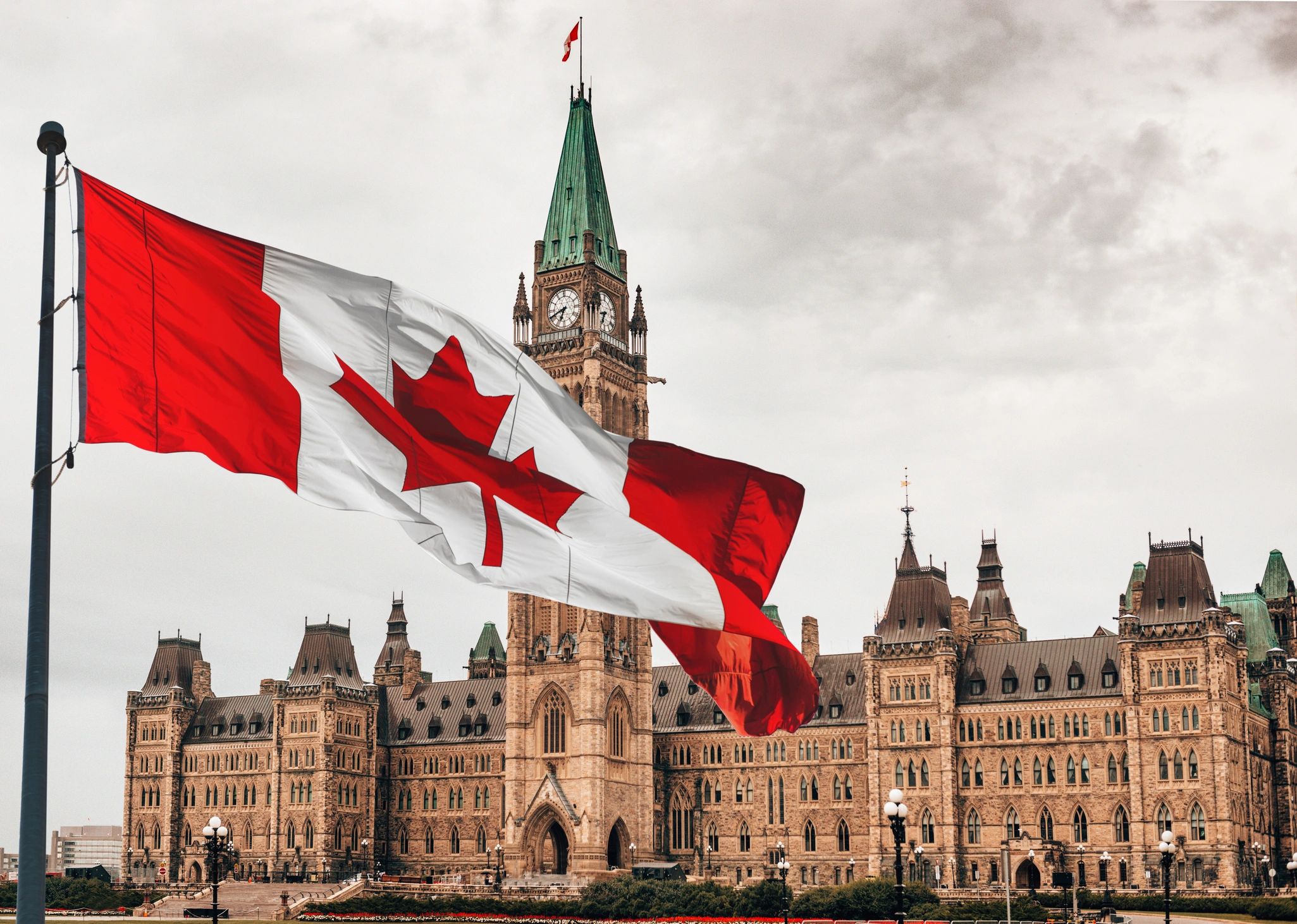 Canadian flags flying in front of the Parliament Buildings in Ottawa, Ontario, Canada.