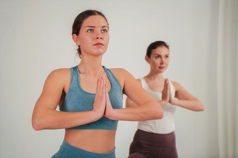 Dedicated women performing yoga poses with concentration and serenity, embodying tranquility and balance in their practice while connecting with their inner selves through mindful movements and deep breaths.