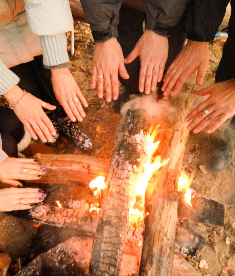 Men's hands, women's, children's hands against a bonfire