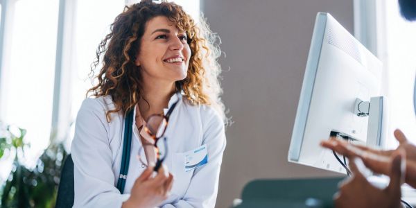 Female doctor smiling and consulting a patient.