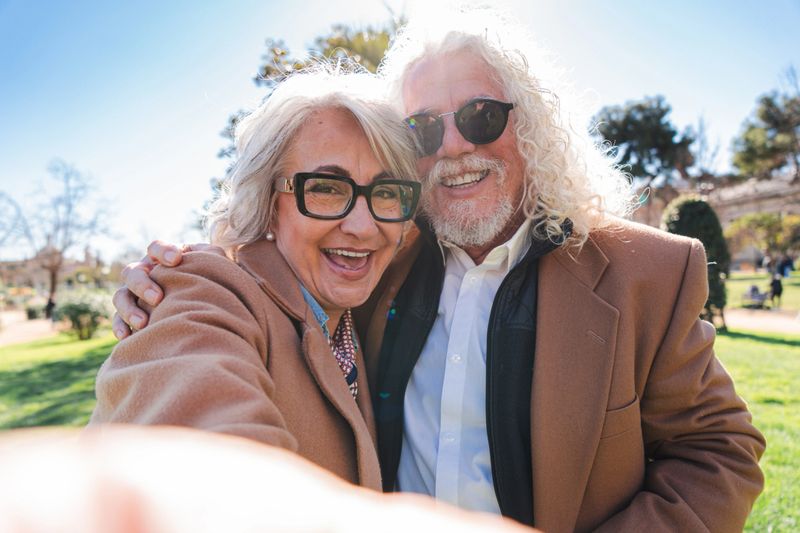Delighted senior couple captures a memorable selfie moment filled with laughter and joy, reflecting their strong bond and affection for each other as they share a lighthearted experience together