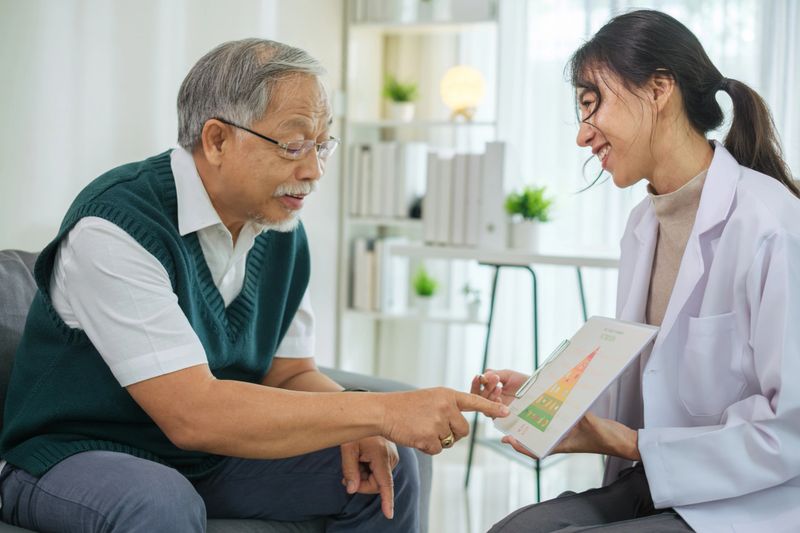 Doctor Explaining Healthy Eating and Food Pyramid to Senior Patient During Nutrition Counseling