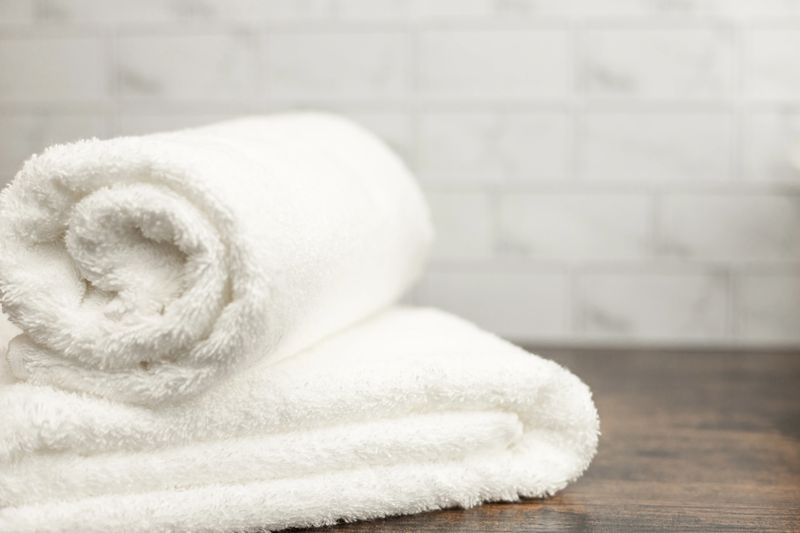White terry towels. Folded white towel. Towel on the shelf. High quality photo