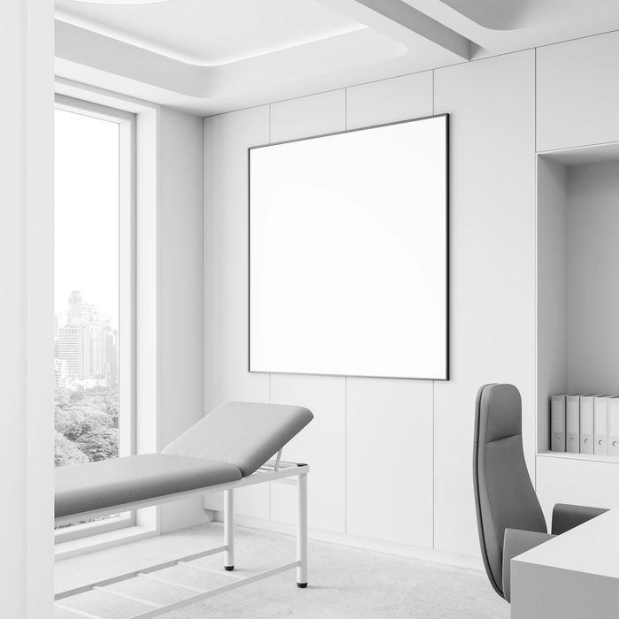 Modern, minimalistic medical examination room with beige and white tones.