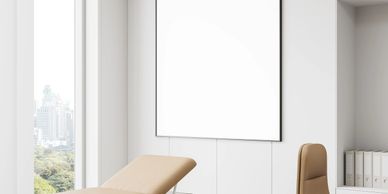 Modern, minimalistic medical examination room with beige and white tones.