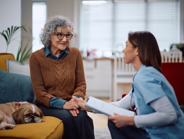 Compassionate caregiver consulting with an older female client.