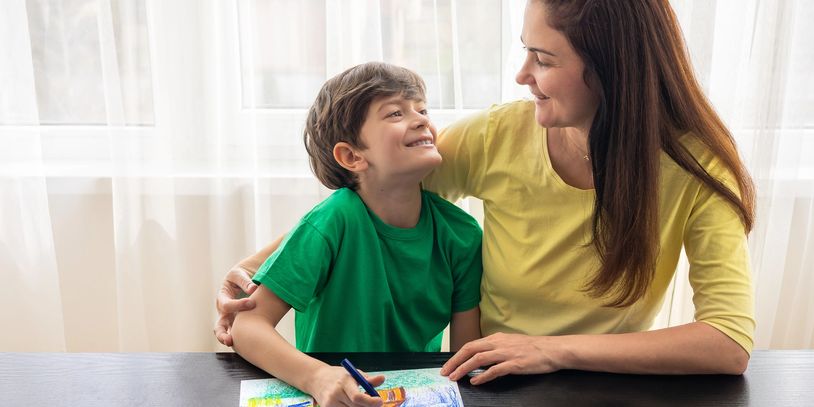 Mother and son sharing a joyful moment while drawing together.