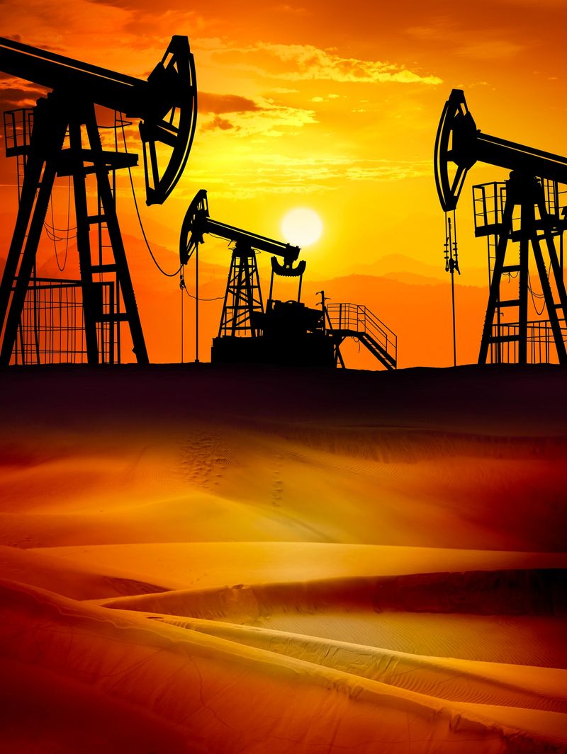 Sunset over drilling rig petroleum pump in the desert