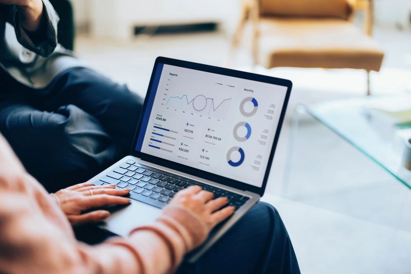 Focused on a laptop, showcasing detailed analytics and reports, representing digital business, teamwork, and strategic planning within a contemporary workspace environment.