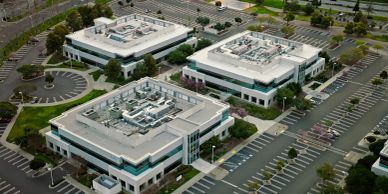 Aerial view of three office buildings in a parking lot.