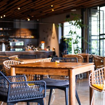 Cozy cafe with wooden tables and wicker chairs.