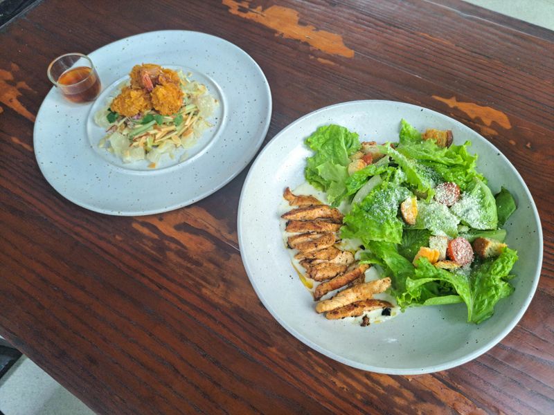 Chicken Gladiator Salad With Mix Salad Served, Roasted Chicken, Tomato Cherry, Croutons And Dressing. Yum Som O Or Thai Pomelo Salad With Mango, Cucumber, Pomelo, Breaded Shrimp Served With Som O Dressing. Salad Food Menu.