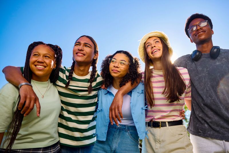 Group of teenager friends embracing and looking up at the sky
