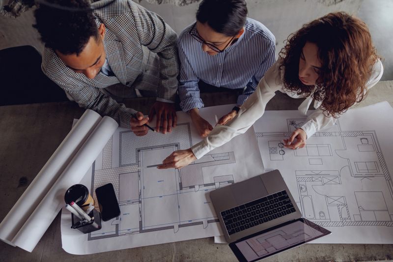 A team engaged in a collaborative discussion about architectural blueprints within a contemporary workspace