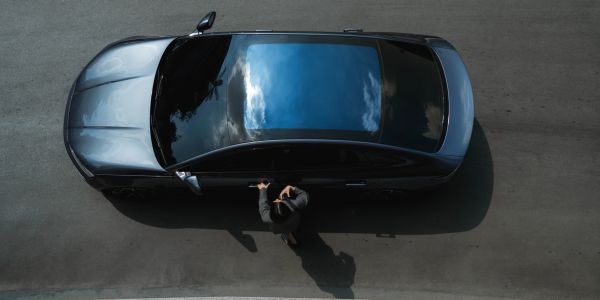 Top view of a person opening a car door.