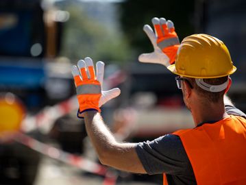 Construction worker signaling with hands.