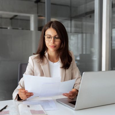 Woman reviewing documents at work desk.