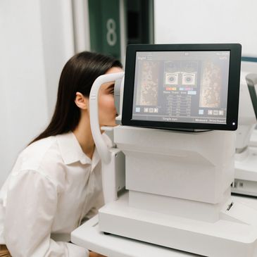 A woman undergoing an eye examination using advanced diagnostic equipment.