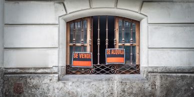 Window with signs saying 'For Sale' and 'For Rent'
