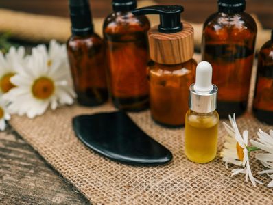Amber glass bottles and a dropper bottle with daisies on burlap.