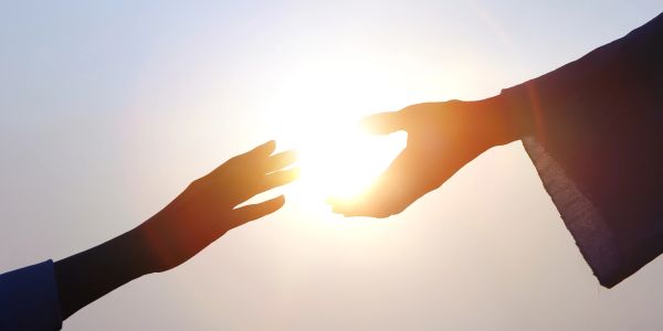 Two hands reaching towards the sun.