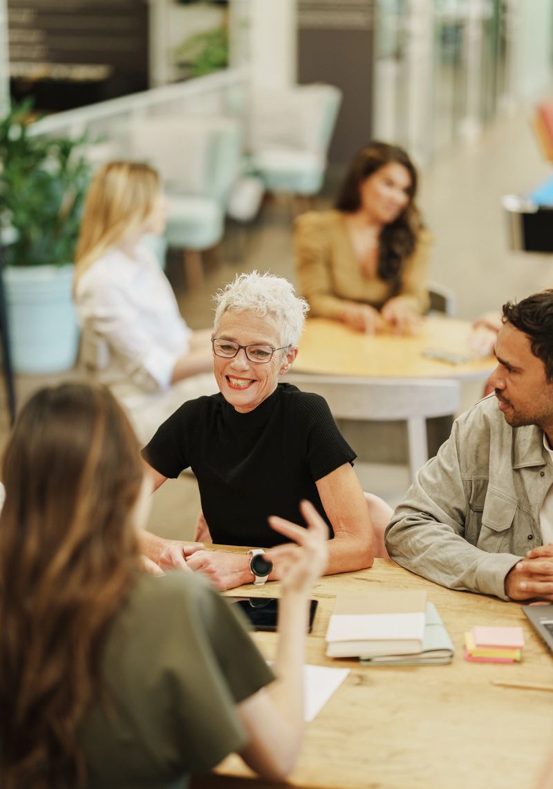 Diverse creative team engaged in lively conversation in a collaborative workspace