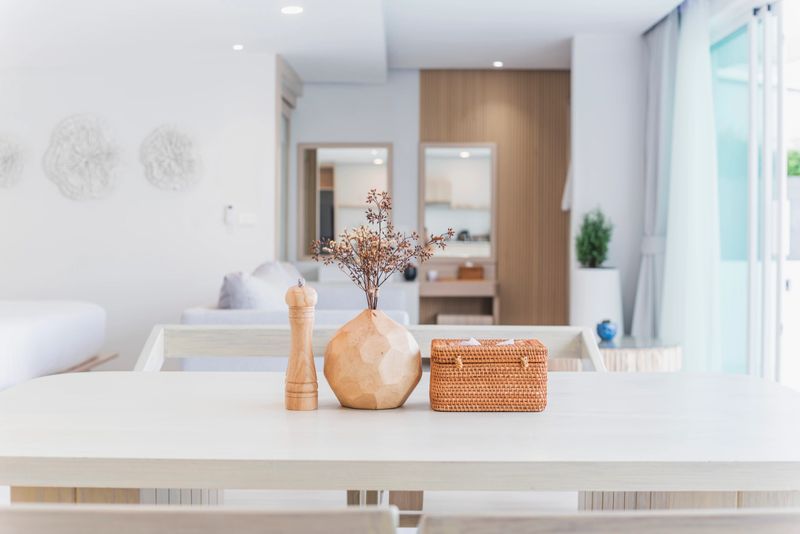 Modern kitchen interior, wooden table, blurred background showing the atmosphere of the room, clean design, home cooking area, neutral colors, natural light.