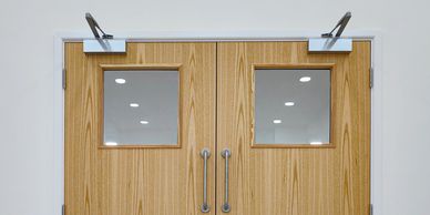 Wooden double doors with glass windows and metal handles.