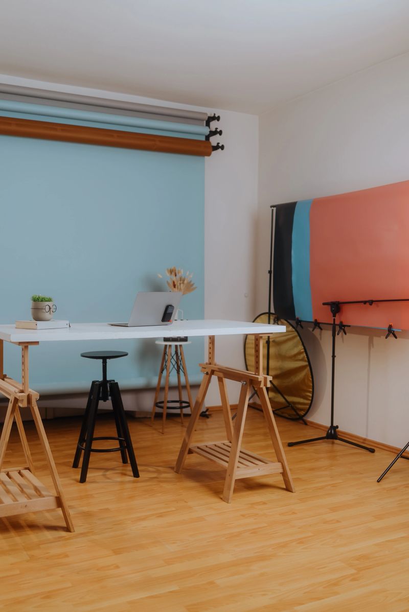 Professional photo studio setup with various backdrops, lighting equipment, and a laptop, prepared for a photography or videography session