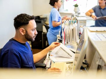 Medical staff working at a hospital reception desk.