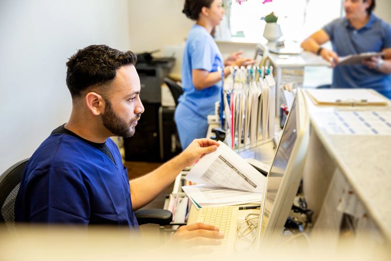 Patients and nurses in the waiting room interacting and checking in