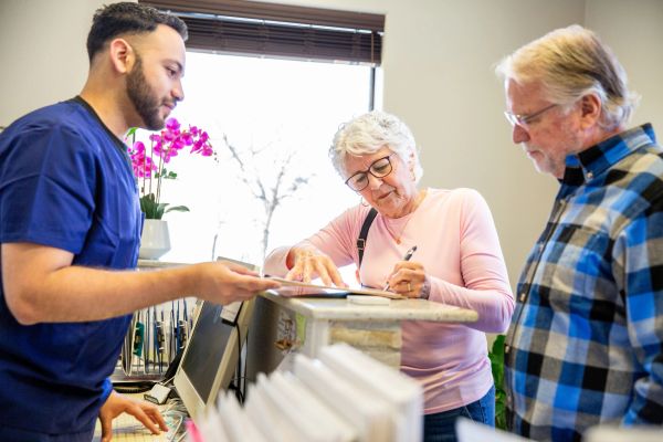 Senior couple checking in at a reception desk.