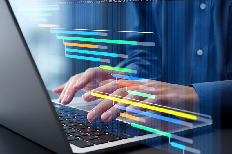 Project management and task scheduling. Timeline and project tracking. Businessman using laptop computer for managing projects and tasks.