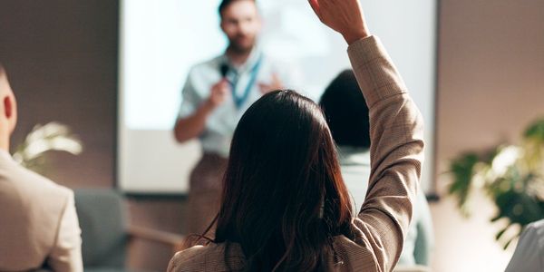 A person raising their hand during a presentation.