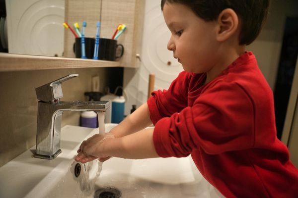 2 year old child washing hands at bathroom sink evokes feelings of independence