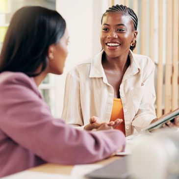 Two women having a friendly conversation indoors.