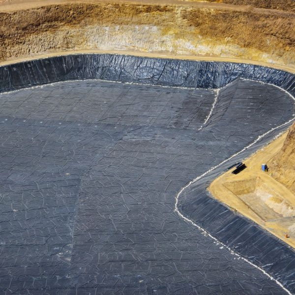 A lined artificial pond or reservoir under construction.