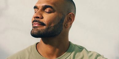 Man enjoying a peaceful moment with eyes closed and slight smile.